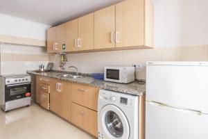 a kitchen with a washing machine and a microwave at Amélia Apartment - Peniche Surf Camp in Peniche