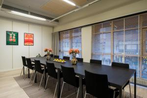 a conference room with a black table and chairs at Hiisi Hotel Lohja in Lohja