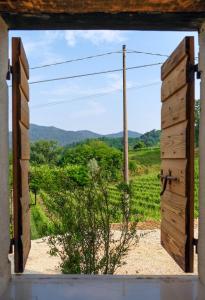 eine offene Tür mit Blick auf ein Feld durch ein Fenster in der Unterkunft Ca' del Biss in Caenere