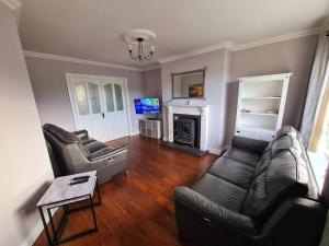 a living room with a couch and a fireplace at Bundoran Seaside Stays House - WiFi, large spacious home in Bundoran