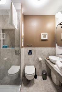a bathroom with a toilet and a sink at Chmielna Warsaw City Centre Apartment in Warsaw