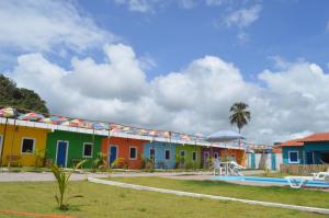 una fila de casas coloridas con piscina en Pousada Vila Vovo Zilda, en Maragogi
