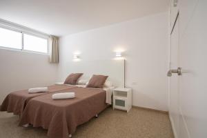 a bedroom with a bed with two pillows on it at Apartamentos Tarahal in San Agustin