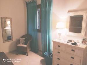 - une chambre avec une commode, un miroir et une commode avec une lampe dans l'établissement Bilocale con giardino posto auto splendida vista, à Montiano