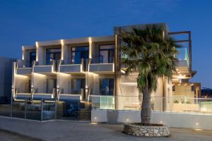 a building with a palm tree in front of it at Pearl SeaBreeze Suites in Rethymno Town