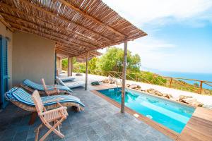 a patio with a bed and a swimming pool at Tenuta Delle Ripalte in Capoliveri