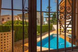 a view of a swimming pool through a window at Adosado al lado del Torreón in Benicàssim