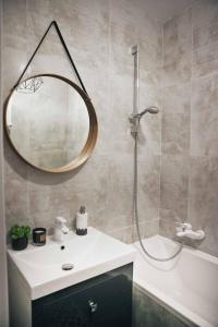 La salle de bains est pourvue d'une douche, d'un lavabo et d'un miroir. dans l'établissement Mieszkanie nad Maltą, à Poznań