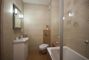 a bathroom with a toilet and a sink and a shower at Apartamenty Marina House in Bydgoszcz +19 photos