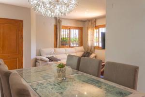 a living room with a dining room table and a chandelier at Adosado al lado del Torreón in Benicàssim