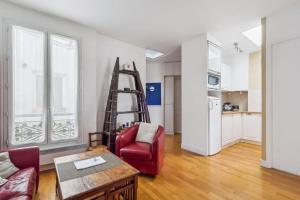 sala de estar con escalera y silla roja en Charming Parisian Apartment, en París