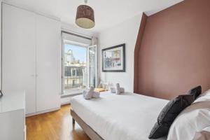 1 dormitorio con cama grande y ventana grande en Charming Parisian Apartment, en París