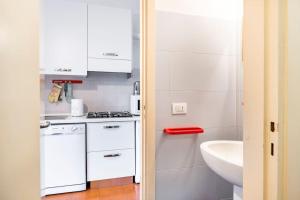 eine kleine Küche mit weißen Schränken und einer Spüle in der Unterkunft CASA MANU FINALE LIGURE in Finale Ligure