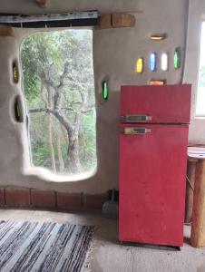 una nevera roja en una habitación con ventana en ECO-LOFT, Sombra de Chañar,- Mallín Córdoba in 