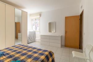 una camera con letto, cassettiera e specchio di Appartamento vista mare Scoglitti a Scoglitti