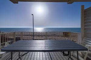 un tavolo da picnic sulla spiaggia con l'oceano sullo sfondo di Appartamento vista mare Scoglitti a Scoglitti