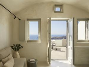 a living room with a white couch and windows at Atoles Retreat in Imerovigli +75 photos