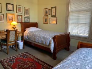 sypialnia z 2 łóżkami, stołem i biurkiem w obiekcie 321# Downtown Antique Rose house w mieście San Antonio
