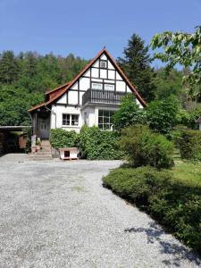 a black and white house with a gravel driveway at Ferienwohnung Natur pur Mühlental Wernigerode in Wernigerode