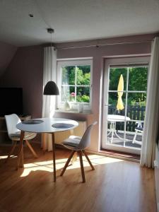 a living room with a table and chairs and a window at Ferienwohnung Natur pur Mühlental Wernigerode in Wernigerode