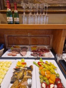 ein Buffet mit mehreren Speisen und Flaschen Wein in der Unterkunft Haus Seeblick Hotel Garni & Ferienwohnungen in Zinnowitz