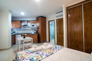 a bedroom with a bed and a kitchen with a table at Apartamentos AMAT - Only Adult - Playa El Bajondillo in Torremolinos