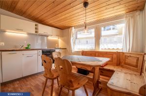 a kitchen with a wooden table and chairs at Chalet Schwarzsee by Arosa Holiday in Arosa