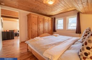 アローザにあるChalet Schwarzsee by Arosa Holidayの木製天井の客室の大型ベッド1台分です。