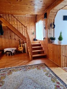 Habitación con escalera de madera y alfombra. en Casa RAI en Predeal