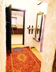 Habitación con espejo y alfombra en el suelo en AnanyaVaas en Dedha