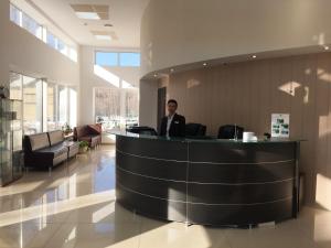 a man standing at a counter in a lobby at Apart-Hotel Kurkino in Moscow