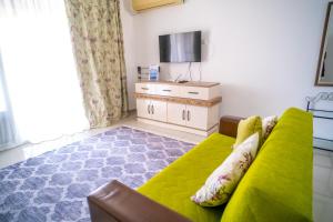 sala de estar con sofá verde y TV en Spacious Three-Bedroom Apartment with Sea View A3, en Kyrenia