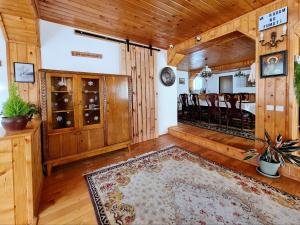 a living room with wood paneling and a dining room at Casa RAI in Predeal