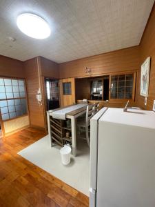 a kitchen with a table and a refrigerator at Chatan Beach House 1 in Hamakawa