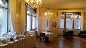 Hotel Markgräfler Hof في كارلسروه: غرفة طعام بها طاولات وكراسي وثريات