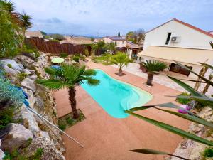 - une vue sur la piscine bordée de palmiers dans l'établissement Villa Natval - 600 m2, à Antibes