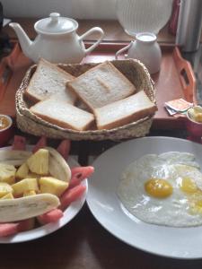 a table with a plate of toast and eggs and bread at Star Canal Cottage in Negombo