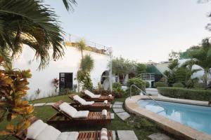 ein Resort mit einem Pool und Liegestühlen neben einem Gebäude in der Unterkunft Saastah Hotel Boutique in Valladolid