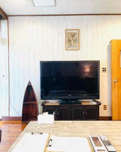 sala de estar con TV de pantalla plana grande en Sunabe Beach House, en Hamakawa