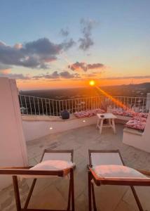 a balcony with a view of the sunset at White Dream in Ostuni