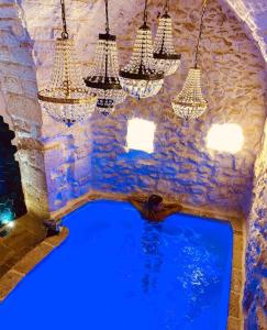 a swimming pool in a cave with chandeliers at White Dream in Ostuni