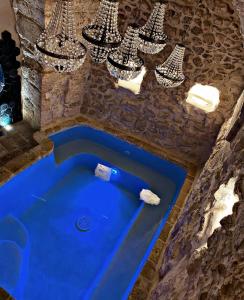 a bath tub in a room with chandeliers at White Dream in Ostuni