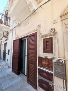 un edificio con porte marroni sul lato di La dimora nel sottano alla strada a Polignano a Mare Altre 48 foto