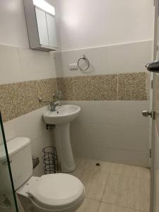 La salle de bains est pourvue de toilettes et d'un lavabo. dans l'établissement Hermoso residencial con piscina,seguridad 24 horas, à Santiago de los Caballeros