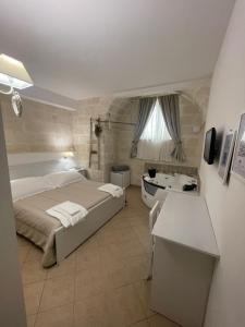 1 dormitorio con cama, bañera y lavamanos en Antica Mateola en Matera