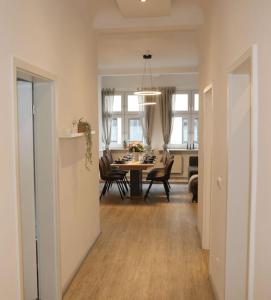 a dining room and living room with a table and chairs at Ferienwohnung Blaßdörfer - Traumhafte Altbauwohnung mit Self-Checkin und 93 qm2 in Bad Kissingen