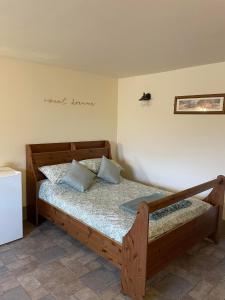 ein Schlafzimmer mit einem Holzbett in einem Zimmer in der Unterkunft Boujie Barn- Shippon in Waterfall