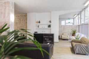 uma sala de estar com um sofá e uma cadeira em Residence Das Nest em Riccione