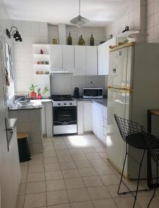 ブエノスアイレスにあるPiso en Belgrano Barrancasのキッチン(白いキャビネット、白い冷蔵庫付)
