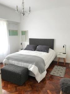 Habitación blanca con cama grande y lámpara de araña. en Piso en Belgrano Barrancas en Buenos Aires